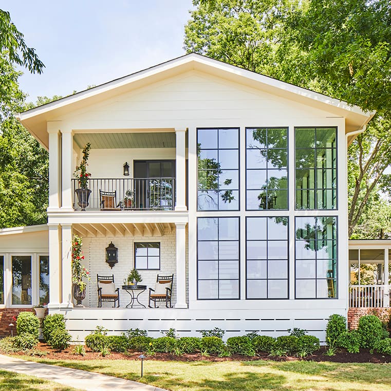 White lakehouse with expansive black-framed windows