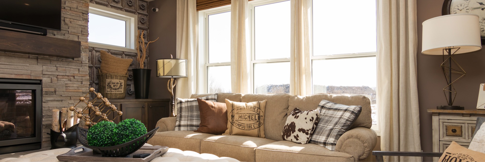 Sunlit living room with tall white-framed windows